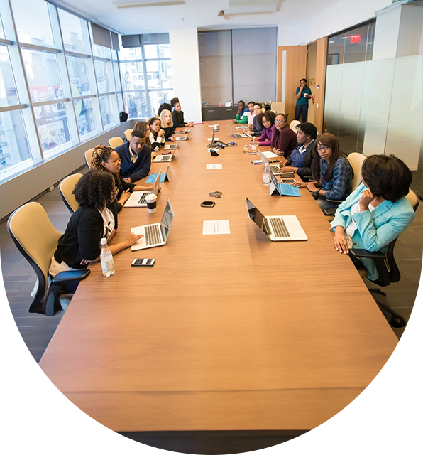 A group of people sitting at a table with laptops.