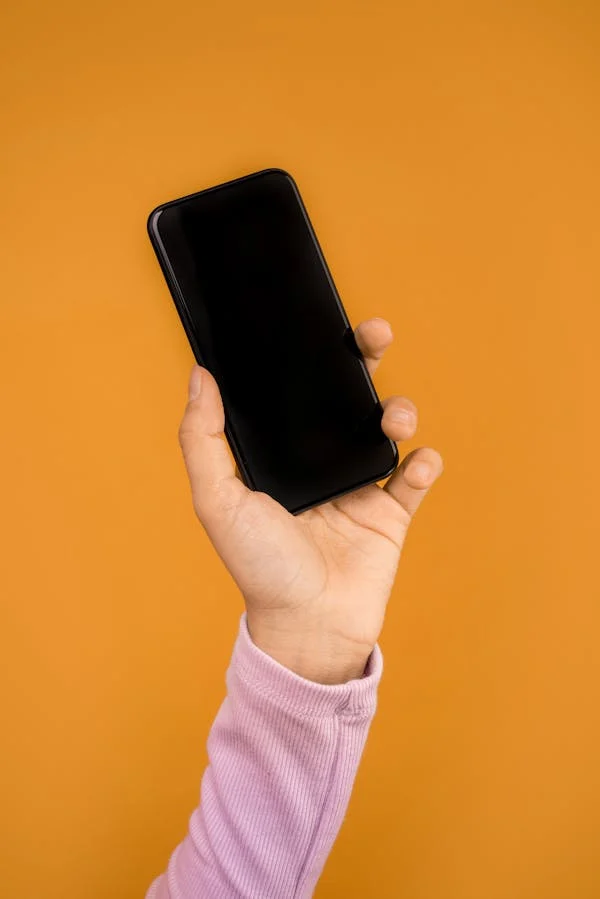 A person holding an iphone in their hand.