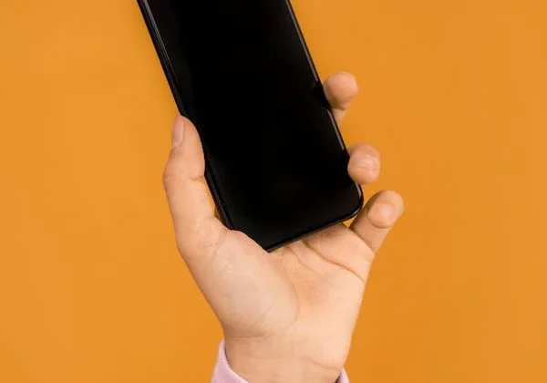 A person holding an iphone in their hand.